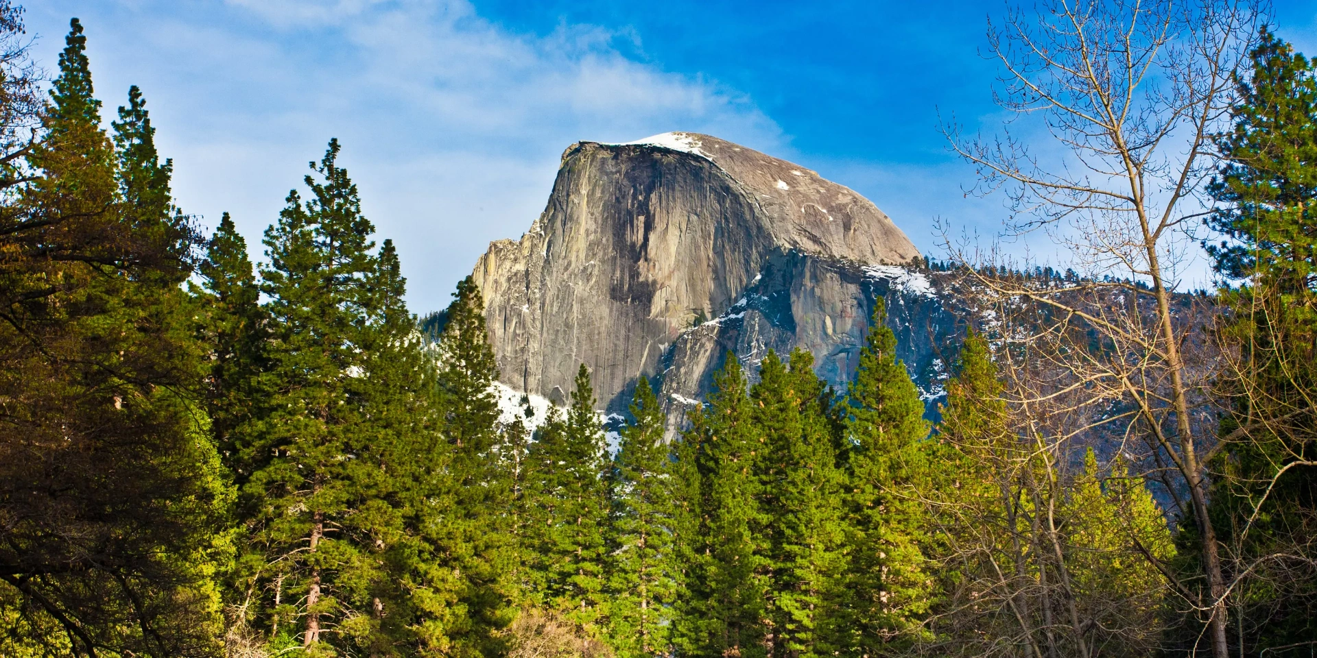 Half Dome at sunrise with alpine glow on granite and mist in the valley